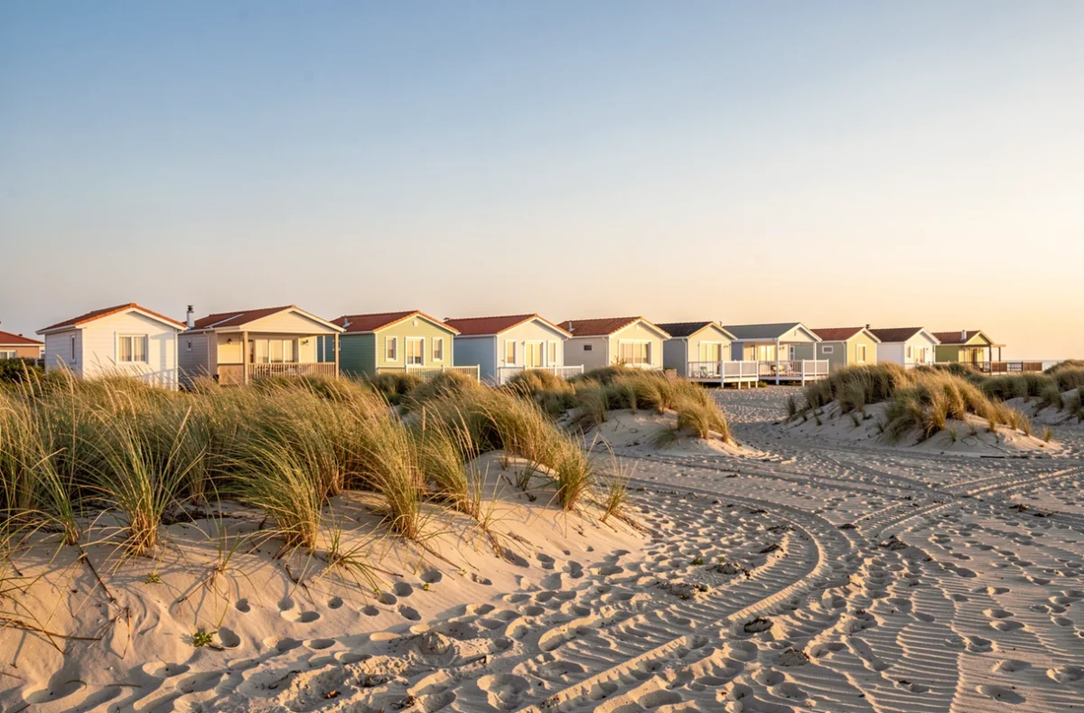 Maisons basses derrière les dunes du lido méditerranéen